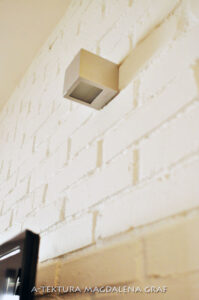 Kinkiet na ścianie z białej cegły